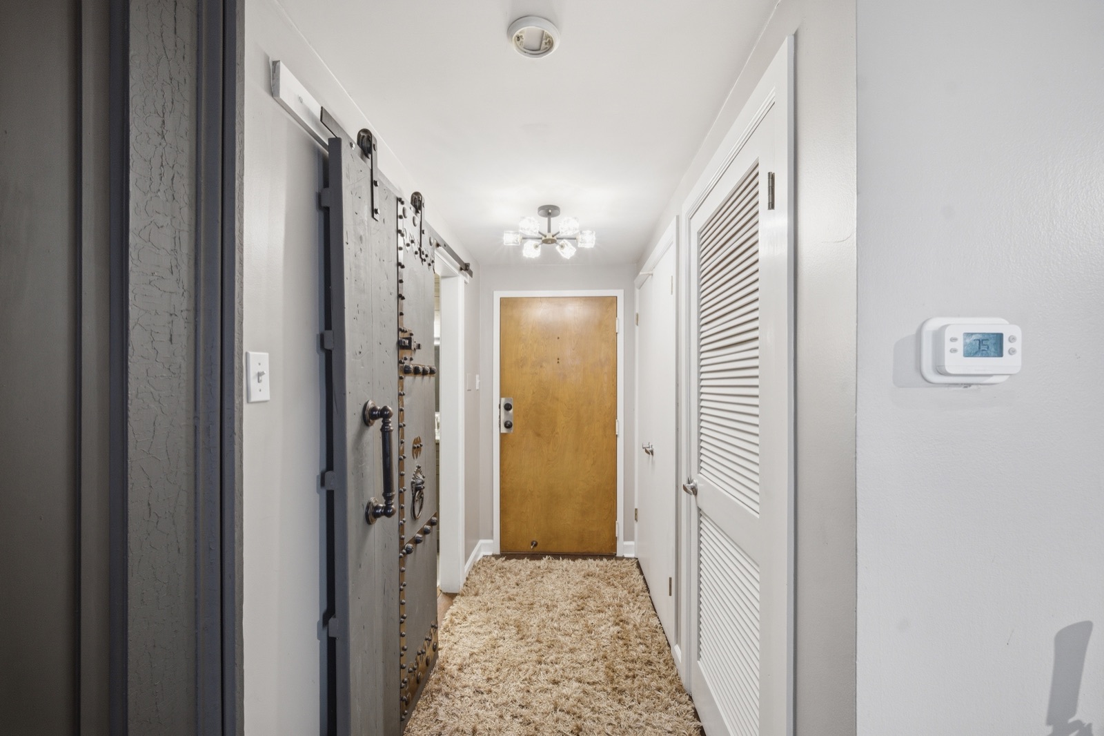 The hallway to the front door, vault door at left