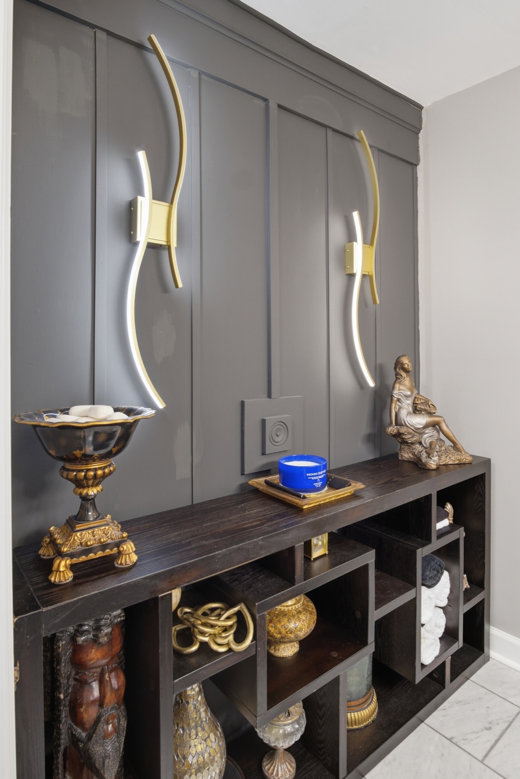 Bathroom storage display with brass lighting